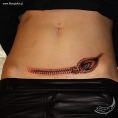 a woman's stomach with an eye tattoo on it