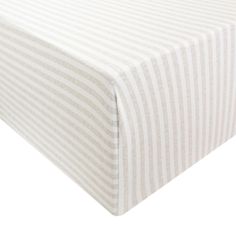 a white and grey striped sheet on top of a bed