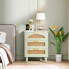 a bedroom scene with focus on the nightstand, bed and plant in the foreground