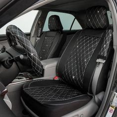 the interior of a car with black leather seats and steering wheel covers in front of it