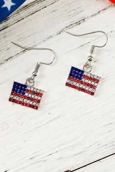 the american flag earrings are on display in front of an american flag