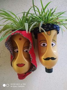 two masks with plants in them on the wall