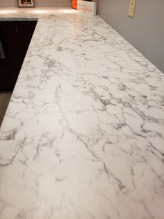 a marble counter top in a kitchen with an orange sign on the wall behind it