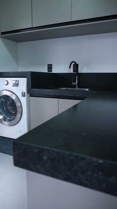 a washer and dryer sitting in a kitchen next to a counter with a sink