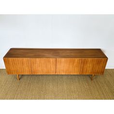 a large wooden cabinet sitting on top of a carpeted floor next to a wall