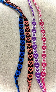 three braided bracelets sitting on top of a white counter next to each other