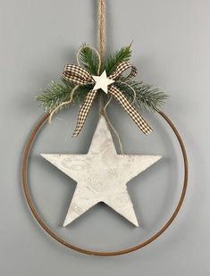 a wooden star hanging on a wall with a ribbon around it and a bow tied to the top