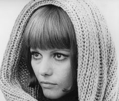 an old photo of a woman wearing a knitted hat and scarf over her head