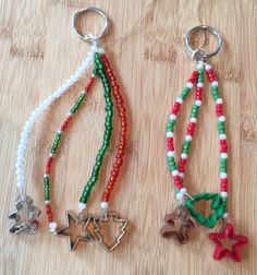 two key chains with charms attached to them on a wooden surface, one has an ornament and the other is a star