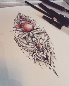 a drawing of a rose on top of a piece of paper with some markers nearby