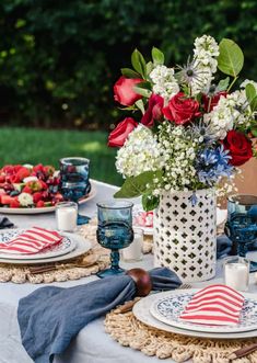 a patriotic table setting with red, white and blue flowers