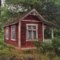 an old red house sitting in the woods