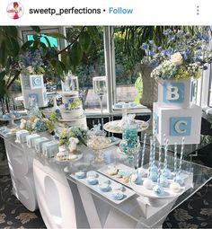 a table topped with cakes and cupcakes covered in blue frosted icing