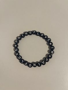 black and white beaded bracelet with the words,'i am to love everyone '