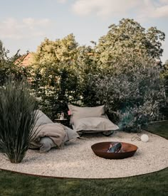 an outdoor seating area with gravel and pillows