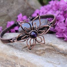 This bracelet is lovingly handcrafted with woven, antiqued and hand polished copper wire.  It will arrive gift boxed and ready for giving.  This bracelet measures 6.5 inches.  Amethyst can be used to simulate the crown or third eye chakra.  It clears negative thinking to create emotional balance and it promotes a higher understanding of ourselves and the world around us. Because of its ability to promote higher thinking, amethyst stimulates creativity and passion. Bronze Hand Wrapped Cuff Bracelet Gift, Bronze Hand Wrapped Cuff Bracelet For Gift, Spiritual Bronze Cuff Bracelet Ideal For Gifts, Bronze Cuff Bracelet Gift, Spiritual Hand Forged Cuff Bracelet Gift, Bronze Wire Wrapped Bracelet For Gift, Spiritual Bronze Cuff Bracelet As Gift, Bronze Copper Cuff Bracelet As Gift, Bohemian Flower Cuff Bracelet As A Gift