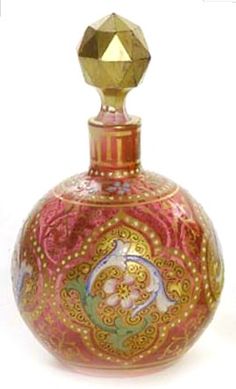 a pink and gold glass bottle with a diamond in the top right corner on a white background