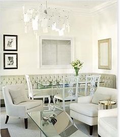 a living room with white furniture and chandelier