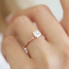 a woman's hand with a diamond ring on it