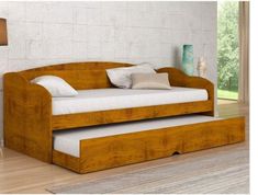 a wooden daybed with white pillows on it