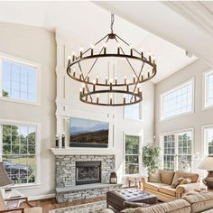 a living room filled with lots of furniture and a chandelier hanging from the ceiling