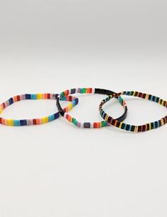 three bracelets with multicolored stripes on them are sitting next to each other