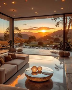 a living room filled with furniture and a large window overlooking the mountains in the distance