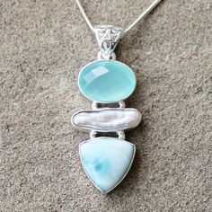 "Make a statement with this elegant hand-crafted semi-precious stone pendant which features gorgeous Blue Larimar, Bidwa Pearl and Chalcedony gemstones.  Stone: Blue Larimar, Bidwa Pearl and FacetedChalcedony  Colour: Blue Metal: 100% Solid Sterling Silver Pendant Size: 3.5 x 1.8 (Excluding Bail) Chain: 18\" solid sterling silver Materials: Each one-of-a-kind piece of jewellery is lovingly hand crafted using top quality semi-precious natural gemstones and solid 925 sterling silver, so that you can treasure your piece for a lifetime.  Gift Boxes: each unique piece is also beautifully packaged in the gift box shown, perfect for giving as a gift or safe keeping. 1 Day Shipping Policy: All items are shipped next business day. However if an item is ordered on a Friday most likely the item will Elegant Turquoise Larimar Jewelry, Aquamarine Pendant With Natural Stones, Aquamarine Pendant Jewelry With Natural Stones, Elegant Larimar Pendant Jewelry, Elegant Larimar Cabochon Jewelry, Unique Larimar Jewelry As A Gift, Elegant Handmade Larimar Jewelry, Hallmarked Larimar Jewelry Gift, Spiritual Larimar Pendant Jewelry