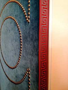 a necklace is hanging on the wall next to a book with a red ribbon around it