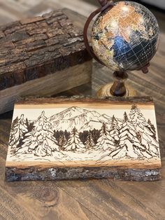 a wooden box with a globe on top of it next to other wood blocks and logs