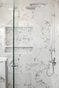 a bathroom with white marble walls and floor