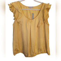 Gold Sleeveless Blouse With Elastic Hem And Shoulder Ruffle Detail. Nwt, Poly Charmeuse, Size L Pit To Pit 21" Length 22" Yellow Sleeveless Top With Ruffles, Summer Tank Blouse With Ruffles, Ruffled Tank Blouse For Summer, Yellow Sleeveless Blouse With Ruffles, Sleeveless Yellow Blouse With Ruffles, Flowy Sleeveless Top With Ruffles, Spring Ruffle Tank Blouse, Spring Tank Blouse With Ruffles, Golden Blouse