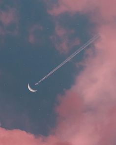 an airplane flying in the sky with a crescent moon