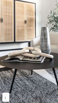 a living room with a black coffee table and white chairs