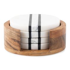 four white and black striped coasters stacked on top of each other in a wooden holder