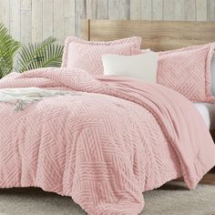 a bed with pink comforters and pillows