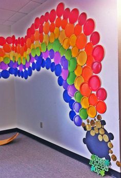 there is a rainbow painted on the wall in an office with balloons attached to it