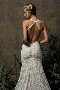 the back of a woman's wedding dress with an open back and lace detailing