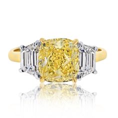 a fancy yellow diamond ring with three baguets on the shoulders and side stones