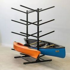 a blue and orange kayak sitting next to a rack with paddles on it