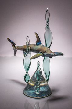 a glass figurine of a shark and fish