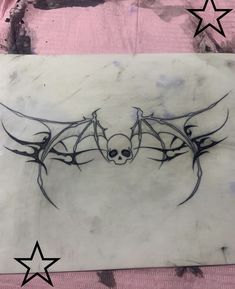 a drawing of a bat on a piece of paper with stars in the back ground