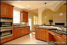 a large kitchen with wooden cabinets and stainless steel appliances