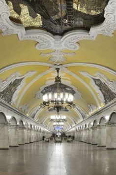 an empty train station with chandeliers and lights on the ceiling is pictured in this image