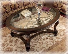 a coffee table with glass top sitting on a rug