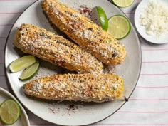 corn on the cob with limes and seasoning next to other food items