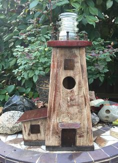 a birdhouse made out of wood and glass jar sitting on top of a table