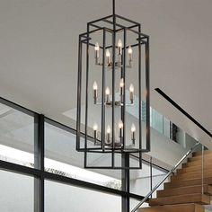 a chandelier hanging from the ceiling next to stairs in a house with glass doors