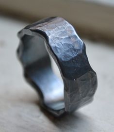 a silver ring sitting on top of a wooden table next to a window sill