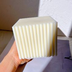 a hand holding a piece of white soap